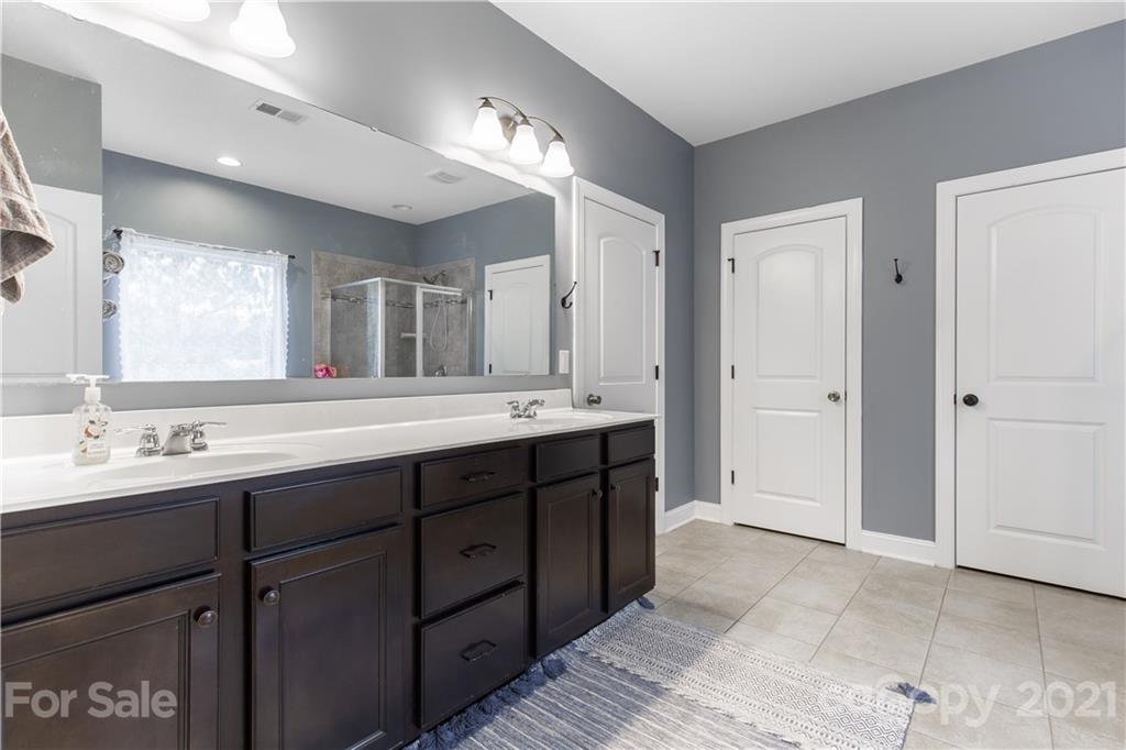 86512 Arrington Road Lancaster, SC 29720 - Photo 27 of 31 a bathroom with a double vanity sink and a mirror