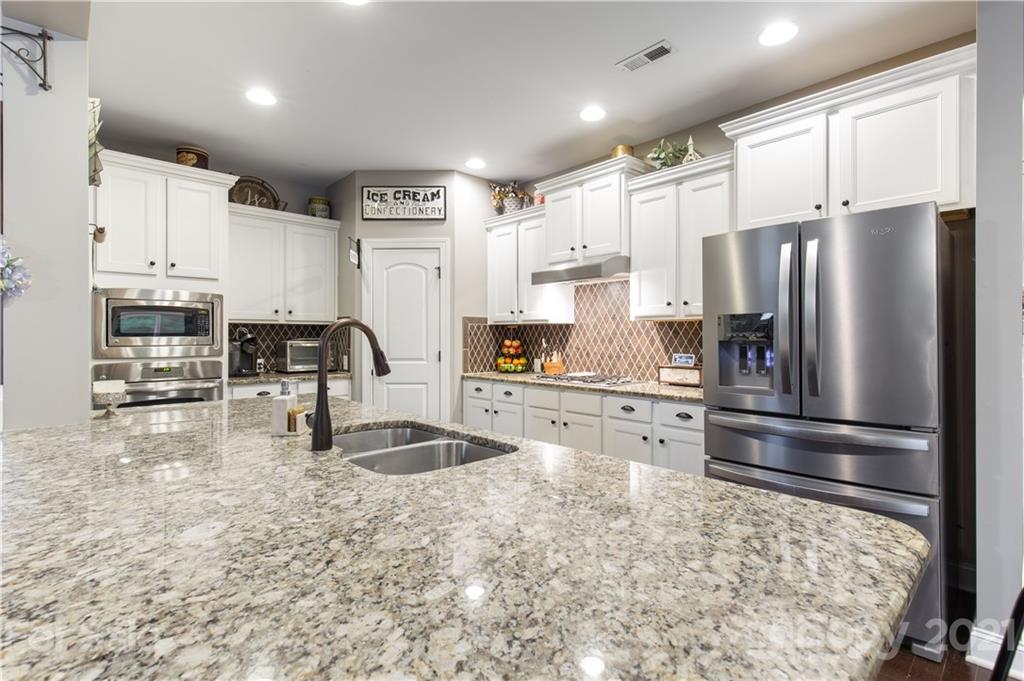 86512 Arrington Road Lancaster, SC 29720 - Photo 10 of 31 a kitchen with stainless steel appliances granite countertop a refrigerator and a stove top oven
