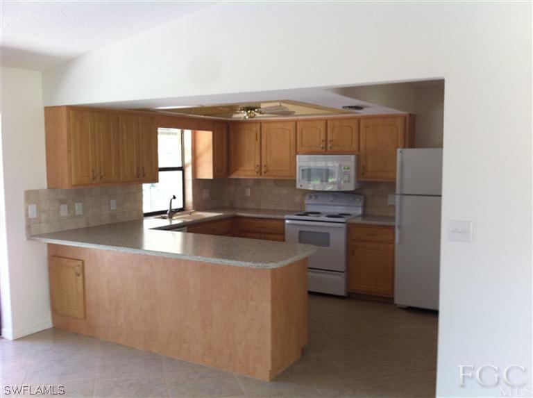 17432 Lebanon Road Fort Myers, FL 33967 - Photo 3 of 20 a kitchen with stainless steel appliances granite countertop a sink a stove and a refrigerator