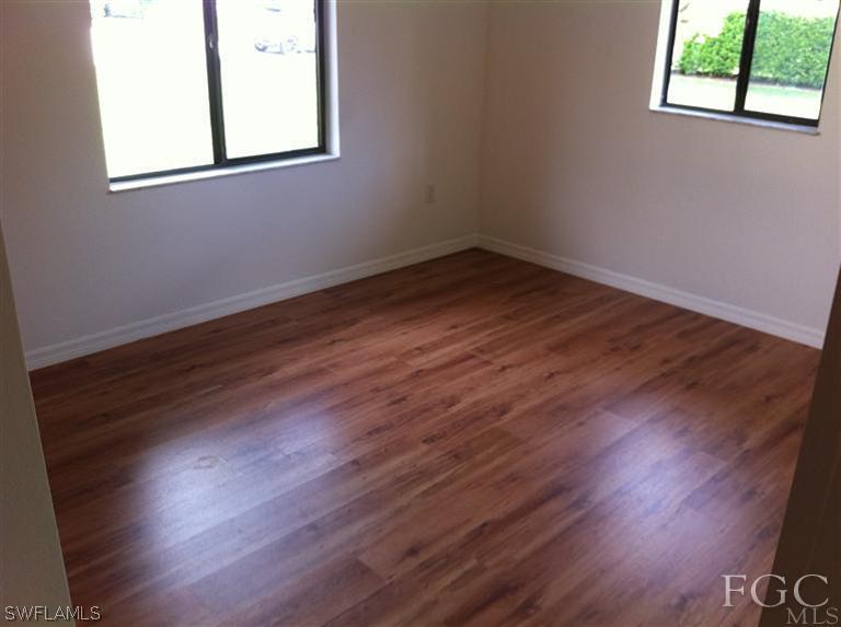 17432 Lebanon Road Fort Myers, FL 33967 - Photo 7 of 20 an empty room with wooden floor and windows