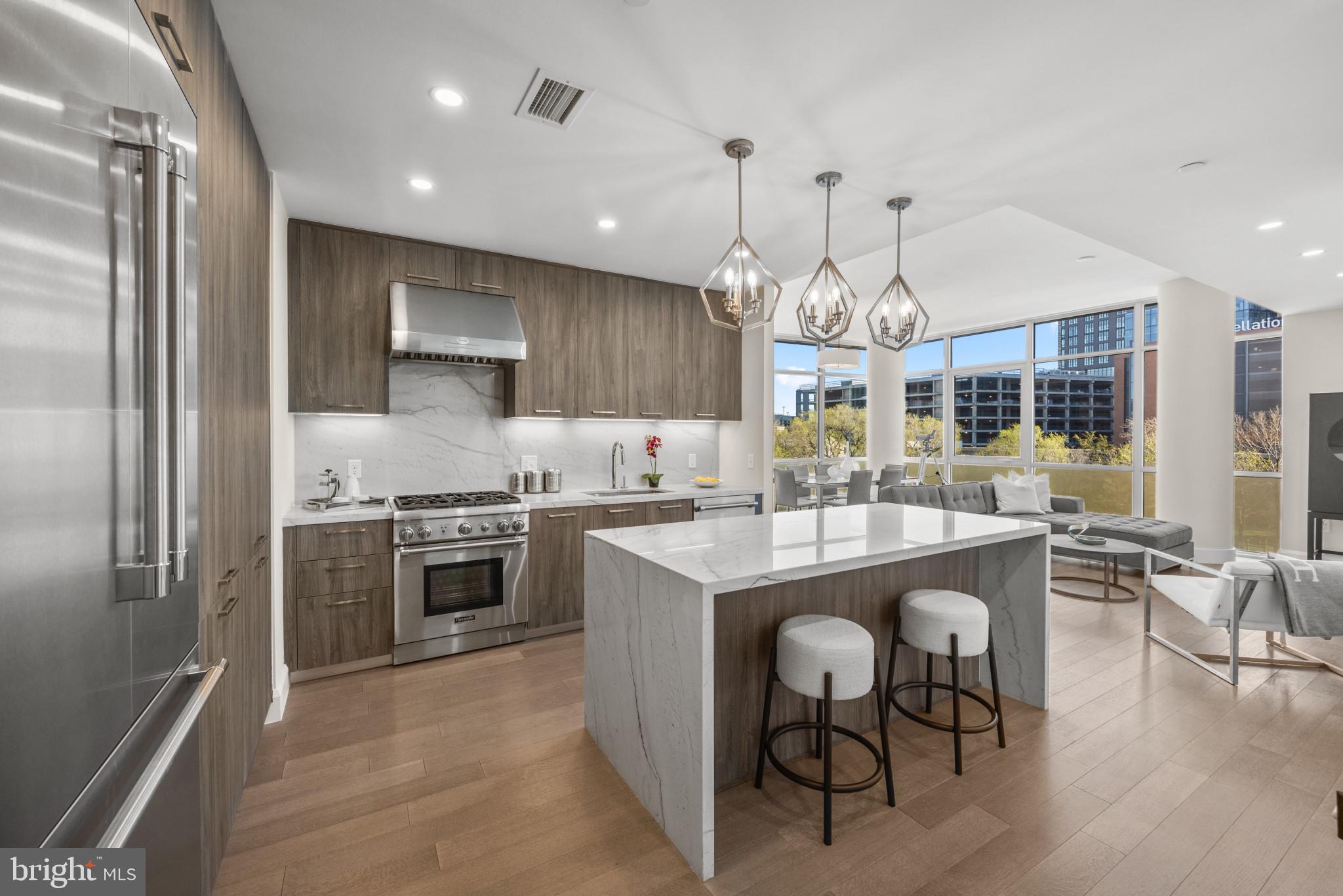 a kitchen with kitchen island granite countertop a stove and a refrigerator