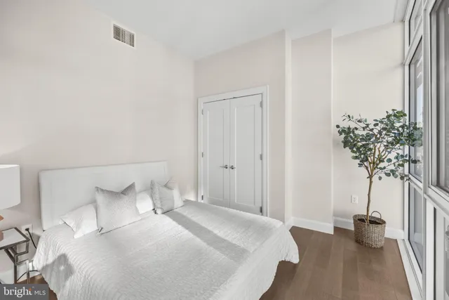 a bedroom with a bed and a potted plant