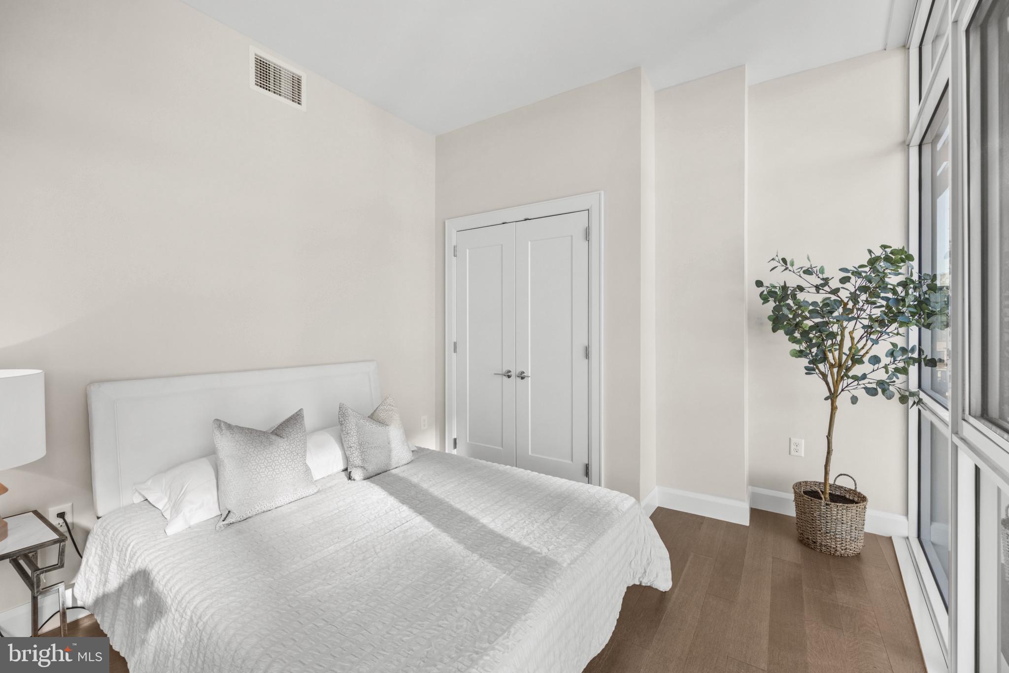 1330 Lancaster Street, Unit C601 Baltimore, MD 21231 - Photo 9 of 32 a bedroom with a bed and a potted plant