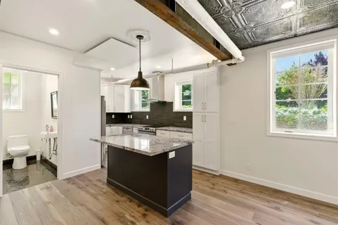 a kitchen with stainless steel appliances kitchen island granite countertop a stove and refrigerator