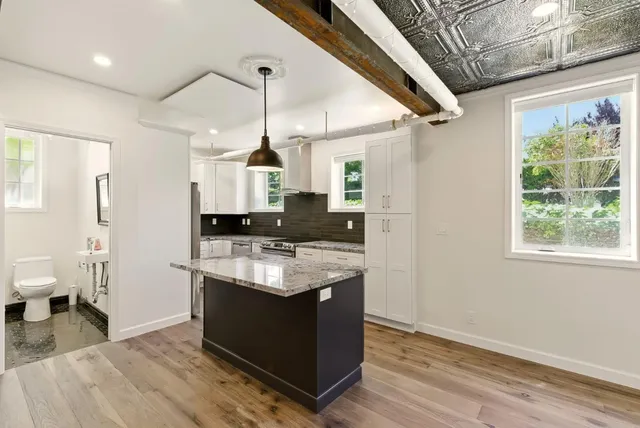 a kitchen with stainless steel appliances kitchen island granite countertop a stove and refrigerator