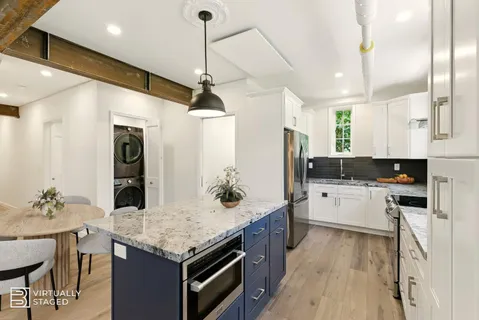 a kitchen with a stove a sink dishwasher a refrigerator and white cabinets with wooden floor