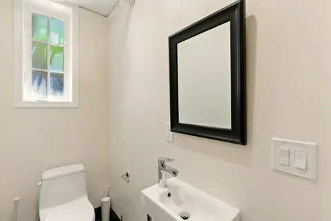 a bathroom with a toilet sink and mirror