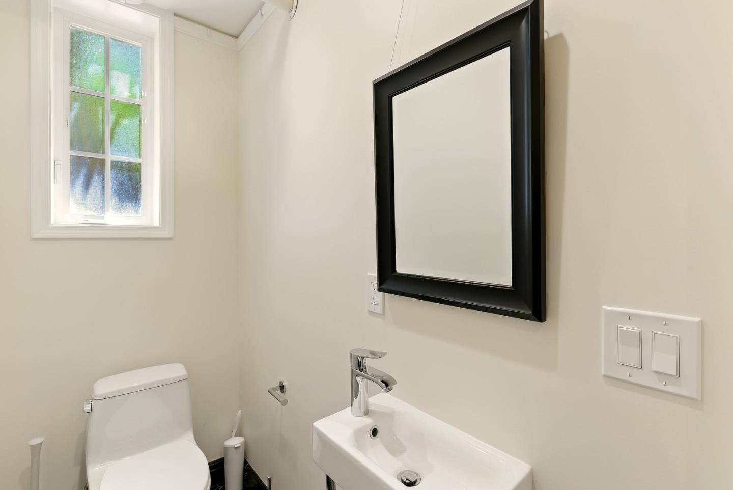 212 Eaton Road, Unit 1 San Mateo, CA 94402 - Photo 9 of 14 a bathroom with a toilet sink and mirror