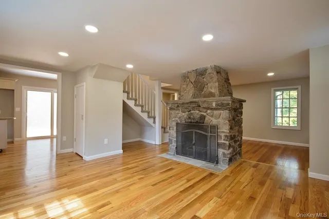 a view of a livingroom with wooden floor a fireplace and window