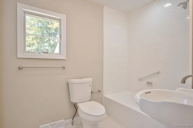 a white toilet sitting next to a bath tub