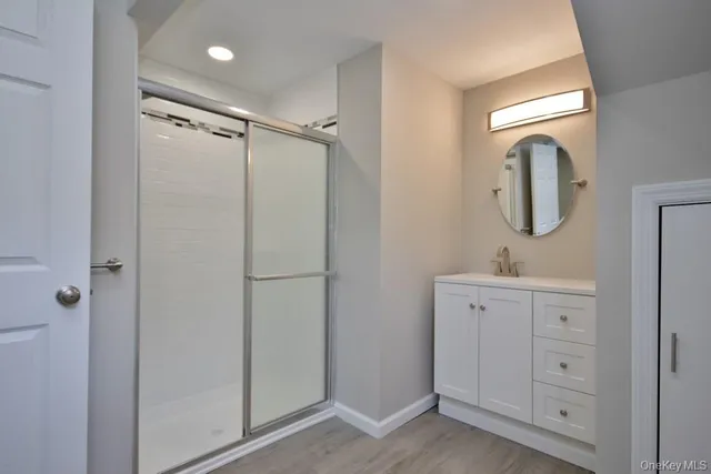 a bathroom with a shower sink and mirror