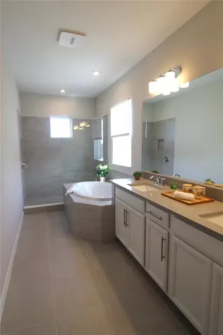 a bathroom with a granite countertop sink and a bathtub