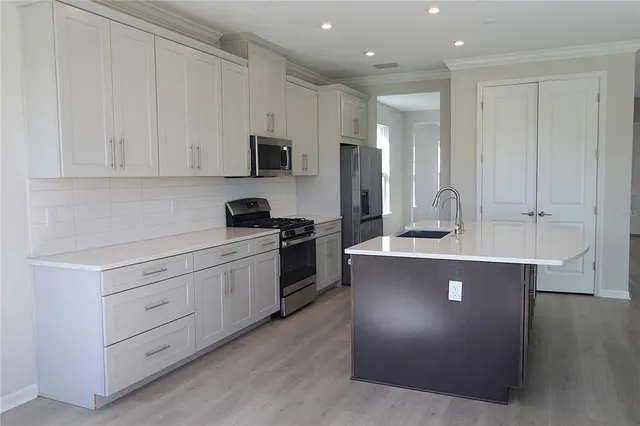 a kitchen with cabinets a sink and appliances
