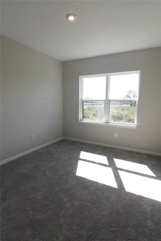 a view of an empty room with closet and a bathroom