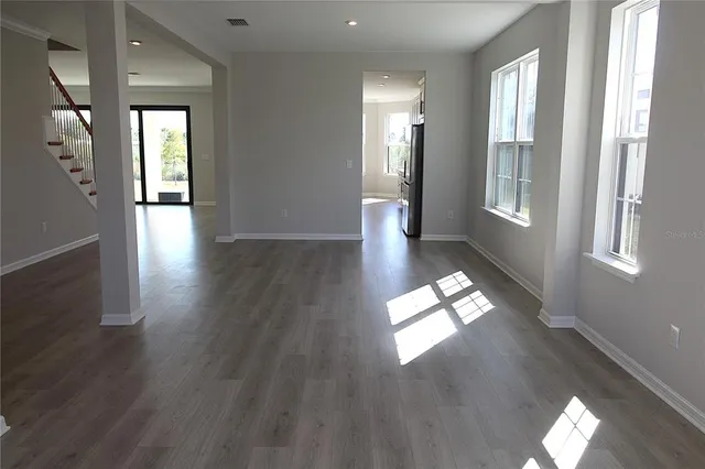 a view of empty room with wooden floor and window