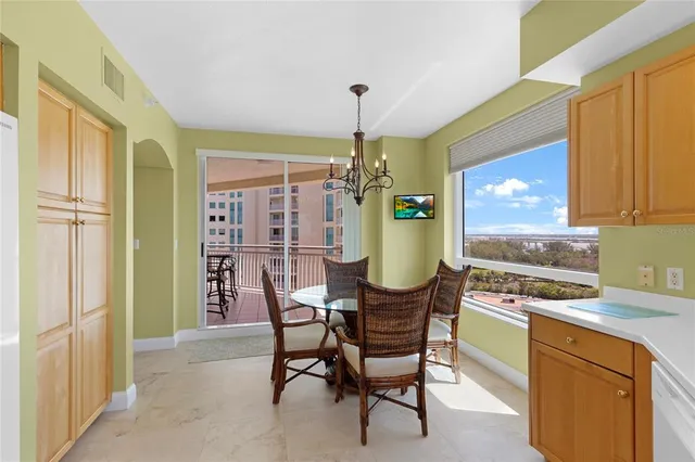 a kitchen that has a table chairs and a refrigerator