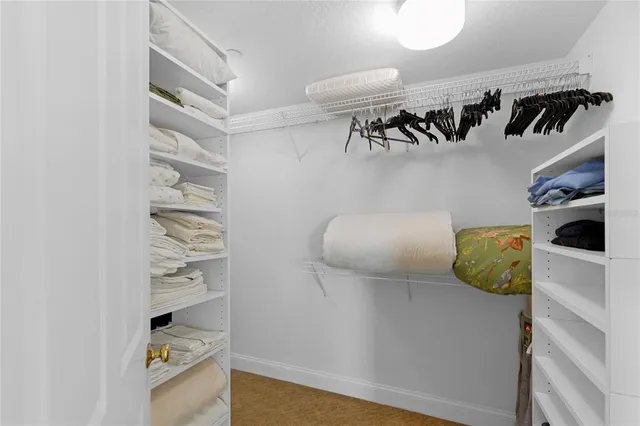 a view of walk in closet with clothes and shoes