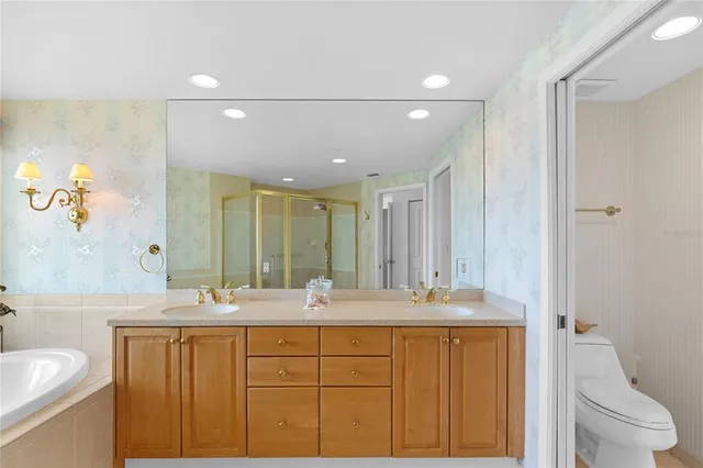 a bathroom with a double vanity sink mirror and toilet