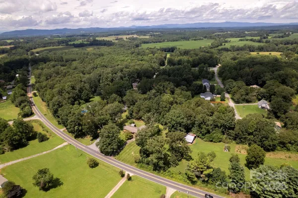 an aerial view of a residential houses with a yard