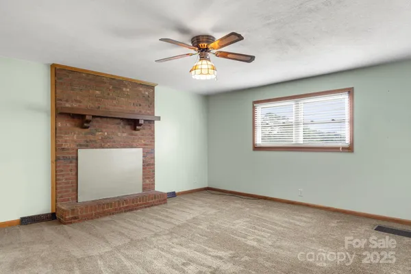an empty room with windows and ceiling fan