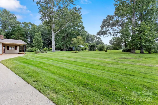 a view of a grassy field with trees