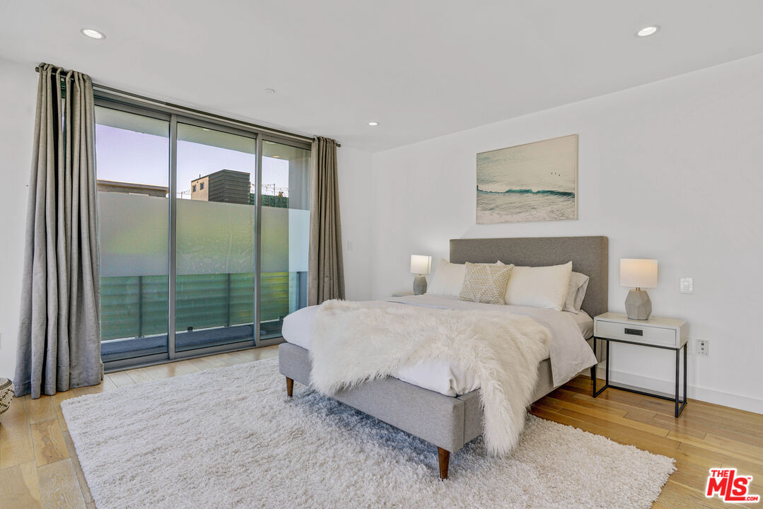 809 Brooks Avenue Venice, CA 90291 - Photo 26 of 32 a bedroom with a bed lamp and a large window