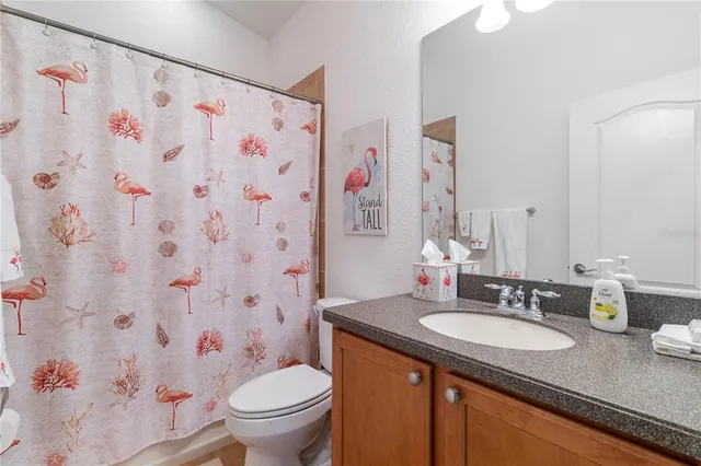 a bathroom with a granite countertop sink a toilet and a mirror