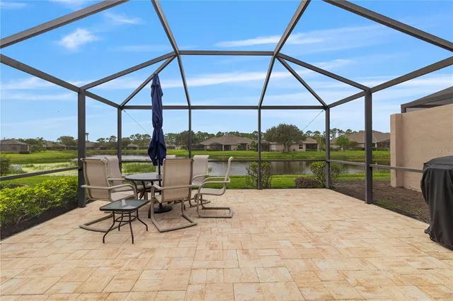 a view of a patio with a table chairs and a yard