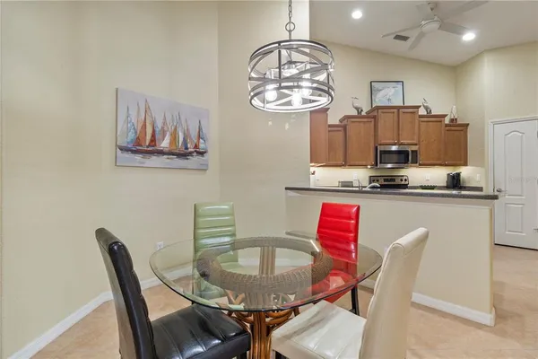 a dining room with furniture a chandelier and kitchen view
