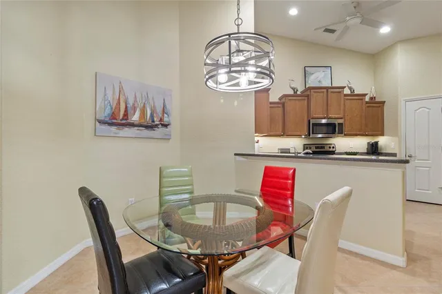 a dining room with furniture a chandelier and kitchen view