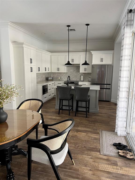 7352 Southeast Seagate Lane Stuart, FL 34997 - Photo 6 of 19 a kitchen with a table chairs and white cabinets