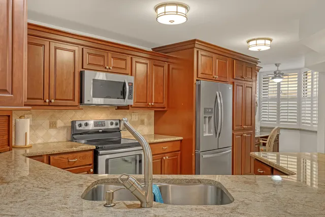 a kitchen with granite countertop cabinets stainless steel appliances and a counter space