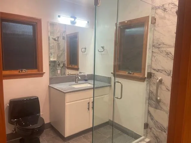 a bathroom with a granite countertop sink a toilet and a mirror