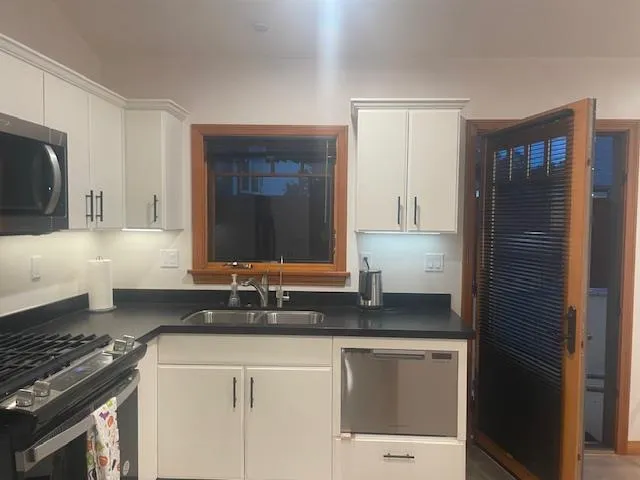 a kitchen with granite countertop a sink stove and refrigerator