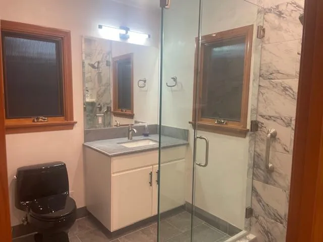 a bathroom with a granite countertop sink a toilet and a mirror