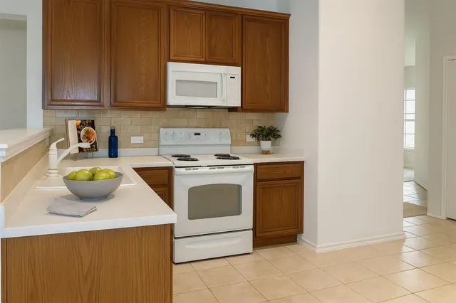 a kitchen with stainless steel appliances a stove a microwave a sink and cabinets