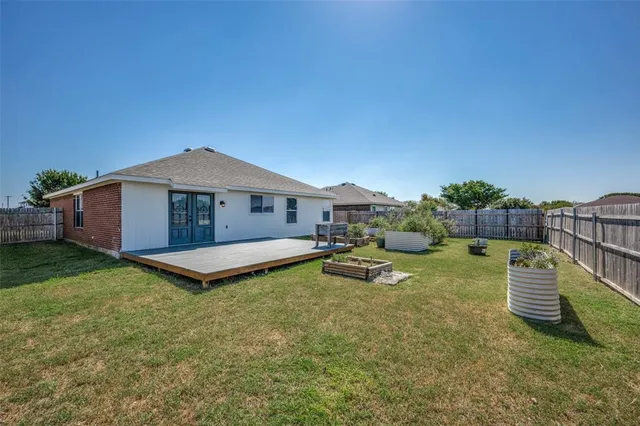a backyard of a house with table and chairs