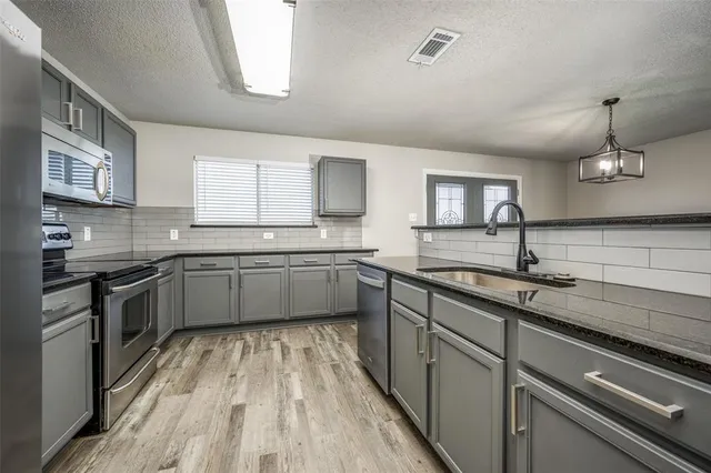 a kitchen with a sink stainless steel appliances and cabinets
