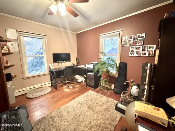 a work room with furniture a rug and a window