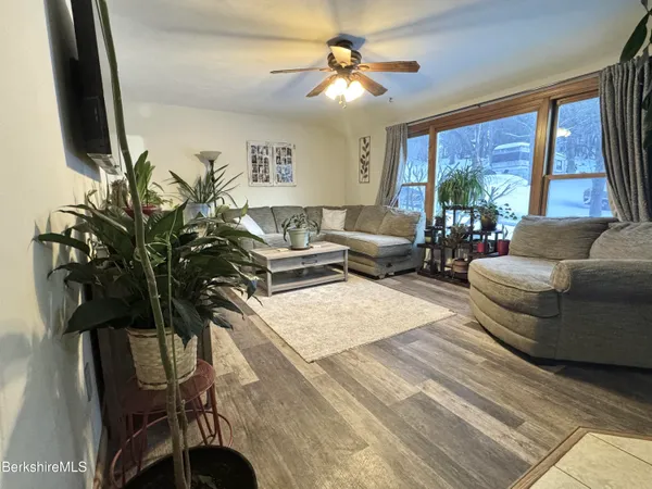 a living room with furniture large window and flat screen tv