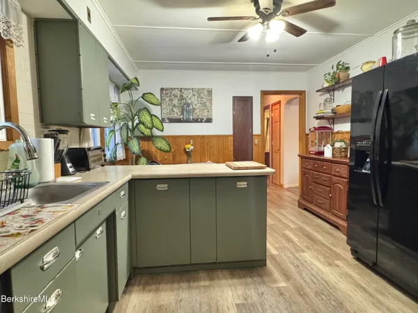 a kitchen with granite countertop a sink and a refrigerator