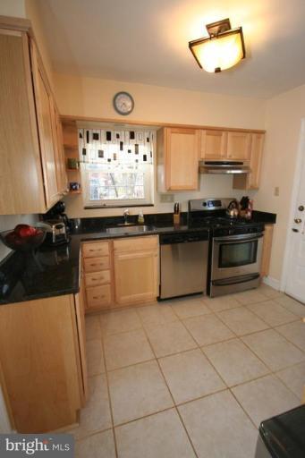 9106 Bradford Road Silver Spring, MD 20901 - Photo 6 of 18 a kitchen with stainless steel appliances granite countertop a stove a sink and a refrigerator
