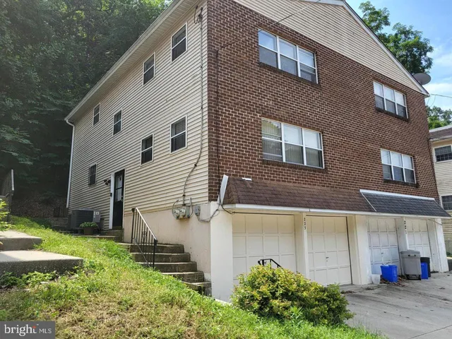 a view of a white house next to a yard