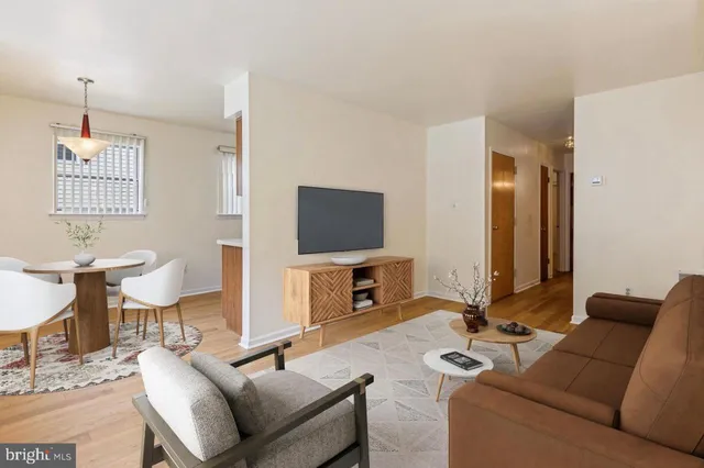 a living room with furniture a flat screen tv and kitchen view