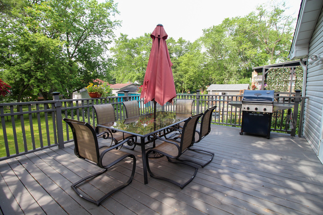 1505 Linden Road Homewood, IL 60430 - Photo 22 of 26 a view of a roof deck with table and chairs a barbeque with wooden floor and fence