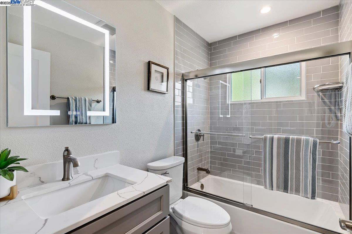 1154 Tilson Drive Concord, CA 94520 - Photo 5 of 25 a bathroom with a granite countertop sink mirror vanity and toilet