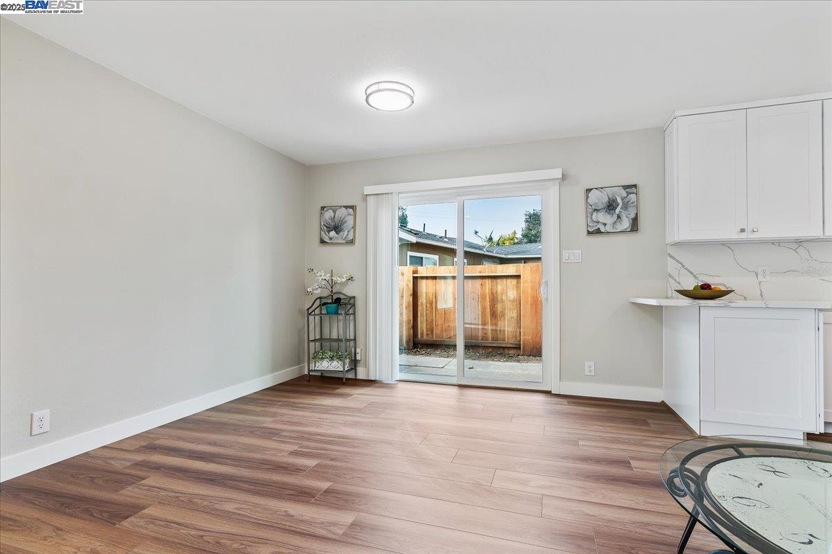 1154 Tilson Drive Concord, CA 94520 - Photo 9 of 25 an empty room with wooden floor a ceiling fan and windows