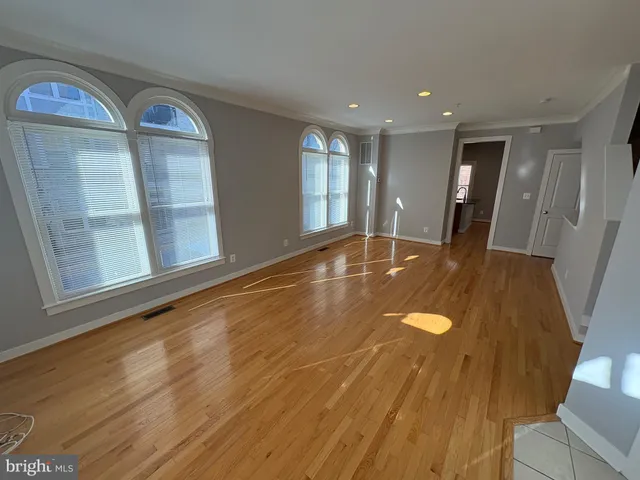a view of empty room with wooden floor