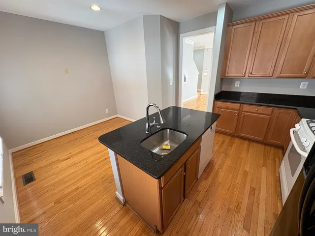 a kitchen with granite countertop sink stove and cabinets