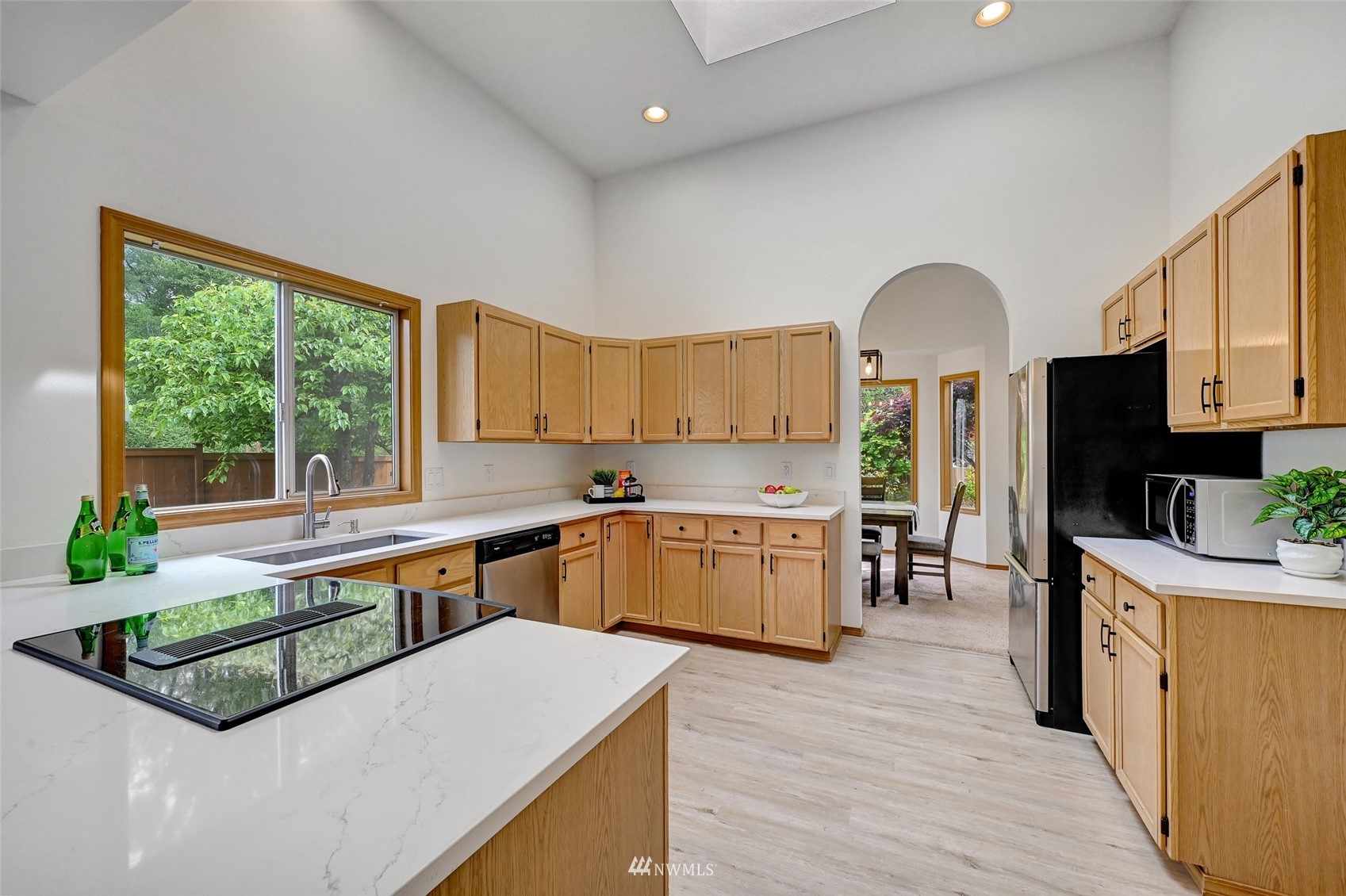 1422 243rd Place Southwest Bothell, WA 98021 - Photo 8 of 40 a kitchen with stainless steel appliances kitchen island granite countertop a stove a sink and a refrigerator